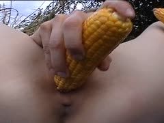 Granny fucks herself outdoors with a corncob